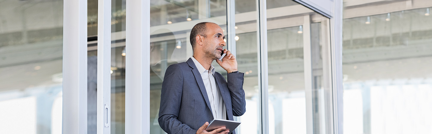 businessman talking on phone and holding tablet