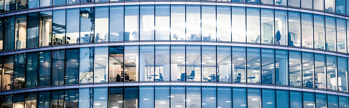 close up of curved office building windows at night